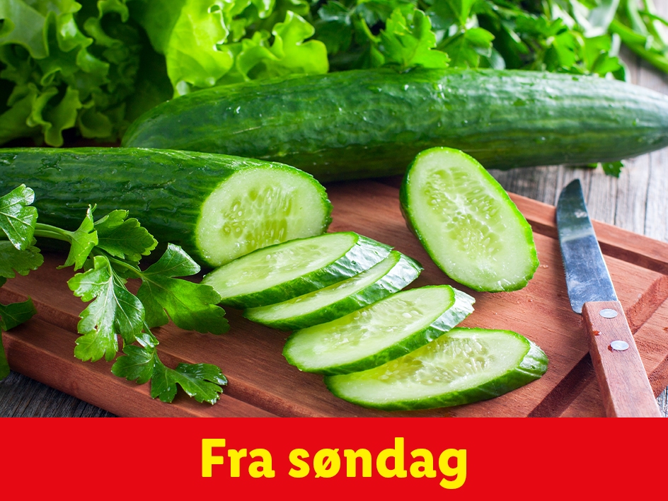 Agurker skåret på et træbræt med persille.