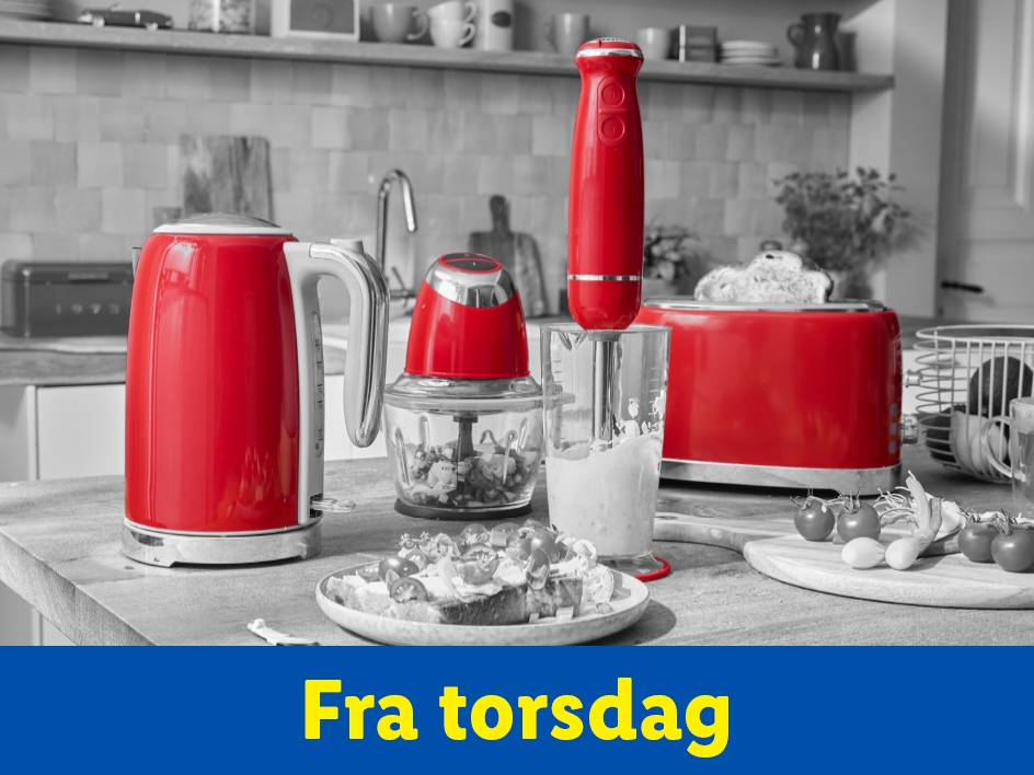 Røde køkkenmaskiner, herunder en elkedel, blender og brødrister, på et køkkenbord.