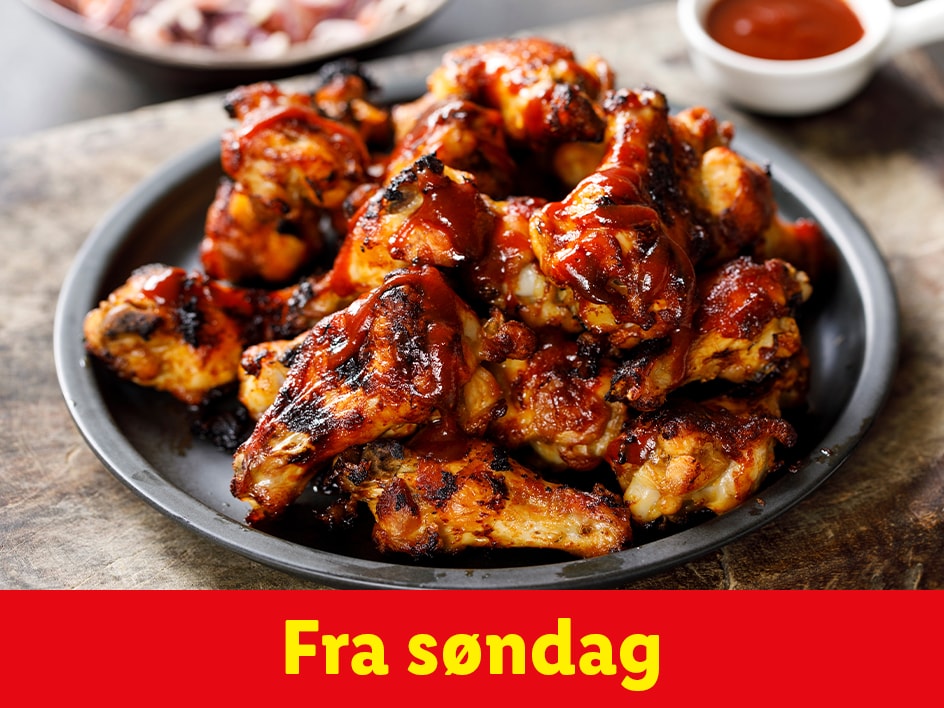 BBQ-kyllingevinger på en sort tallerken, klar til servering fra søndag.