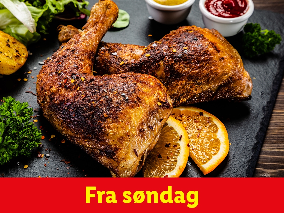 To stegte kyllingelår med appelsinskiver, persille og saucer på en sort skiferplade.