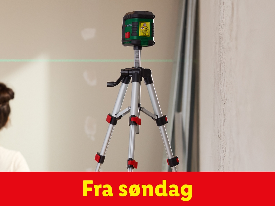 Et laserpas på et stativ, der projicerer en grøn linje på en væg.