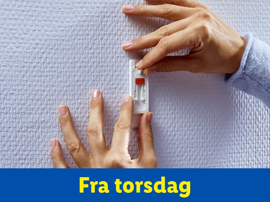 Hænder bruger en vægbeslag til at montere noget på en væg. Fra torsdag.