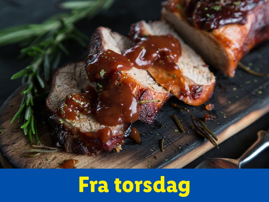 Skiver af stegt kød med sovs og rosmarin på et skærebræt.