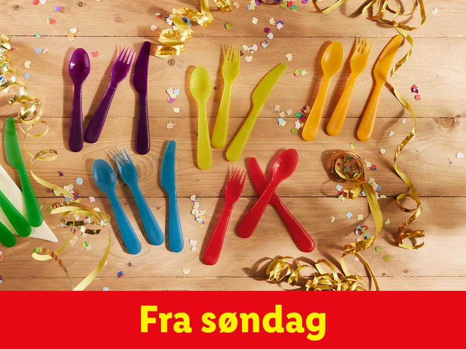 Farverige engangs bestik på et træbord med konfetti og serpentiner. Fra søndag.