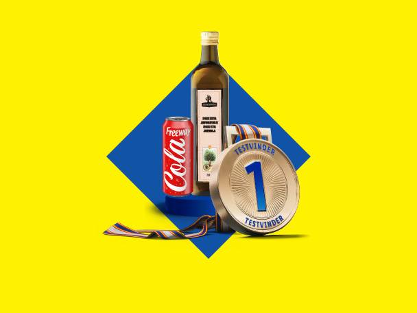 En Freeway Cola-dåse, en flaske olivenolie og en guldmedalje med teksten 'TESTVINDER' på en gul og blå baggrund.