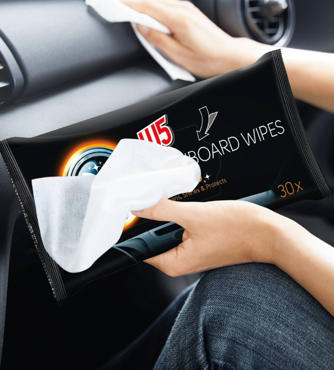 En person holder en pakke 115 Dashboard Wipes og tørrer bilens instrumentbræt.