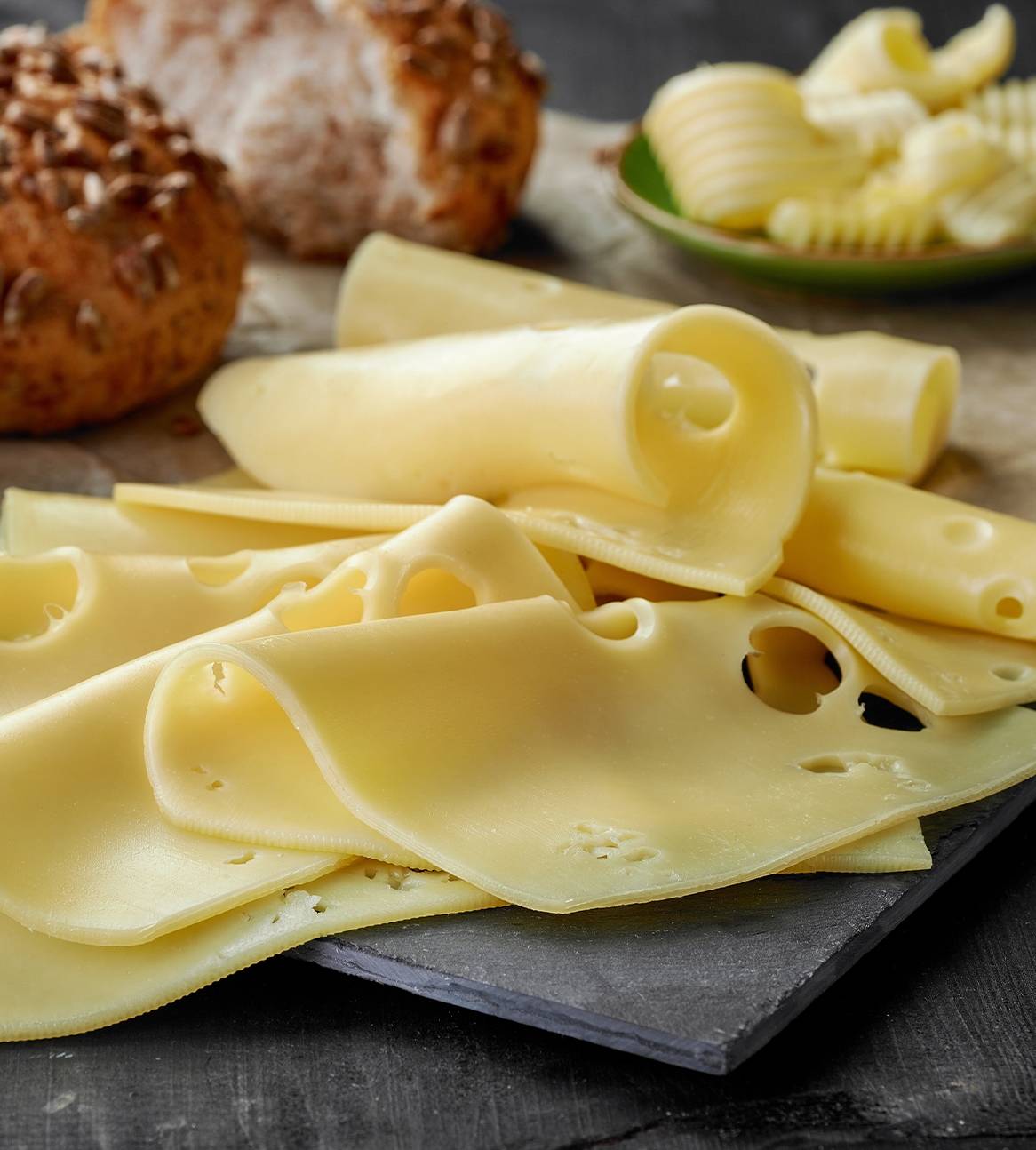Oste- og brødstykker på en mørk overflade.