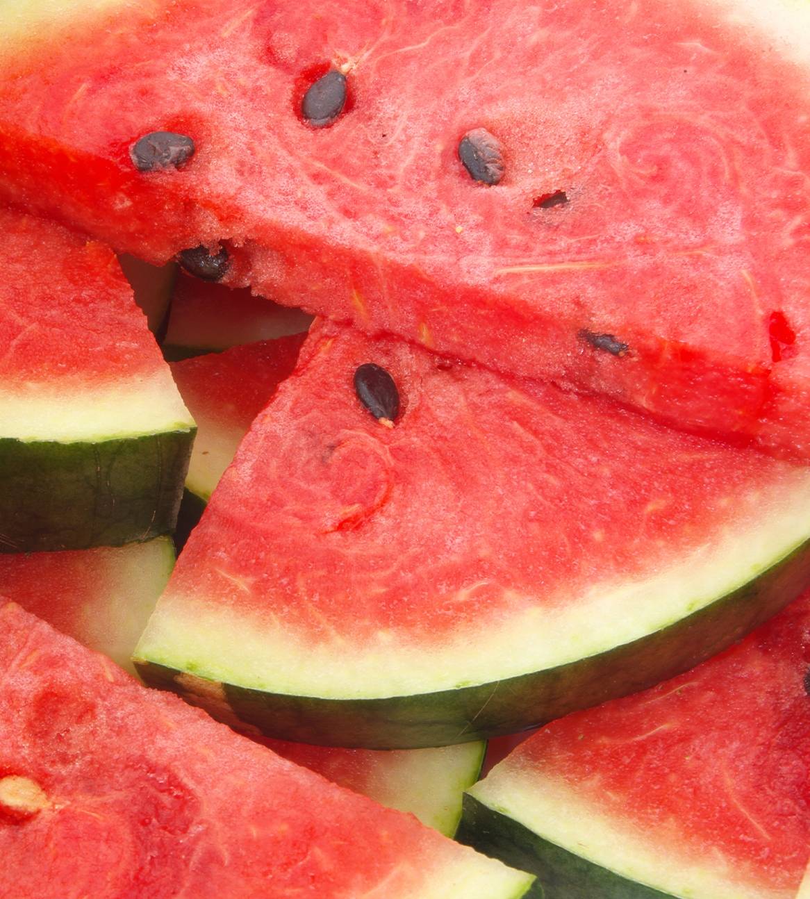 Ferskenfarvede vandmelon skiver stablet oven på hinanden.