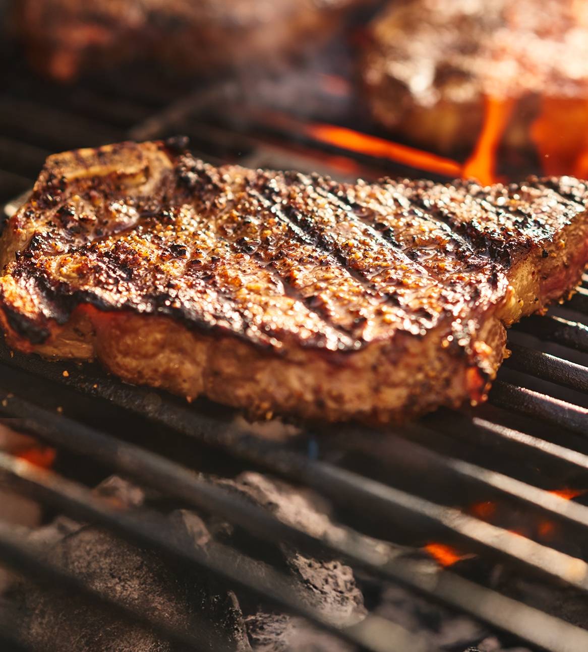 Saftige steaks grilles på en varm grill.