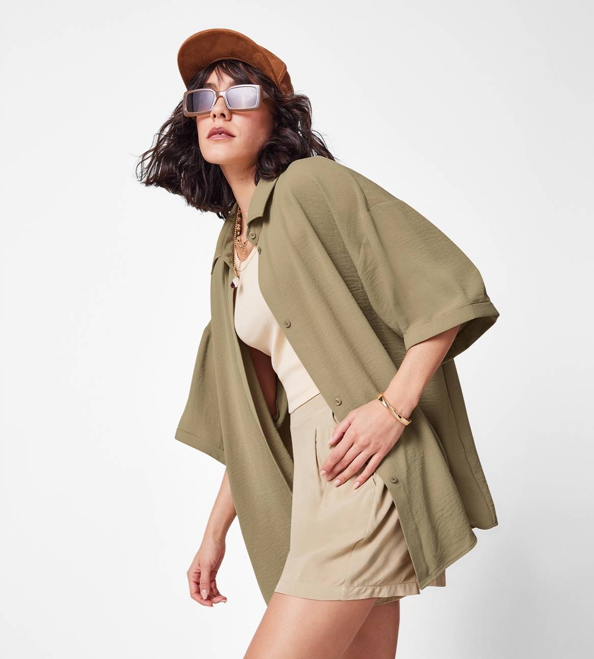 Model iført en olivengrøn skjorte og beige shorts.