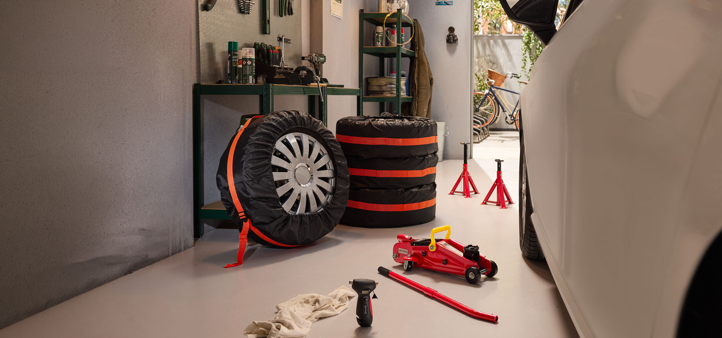 Vinterdæk opbevaret i en garage med en donkraft og donkraftstøtter.